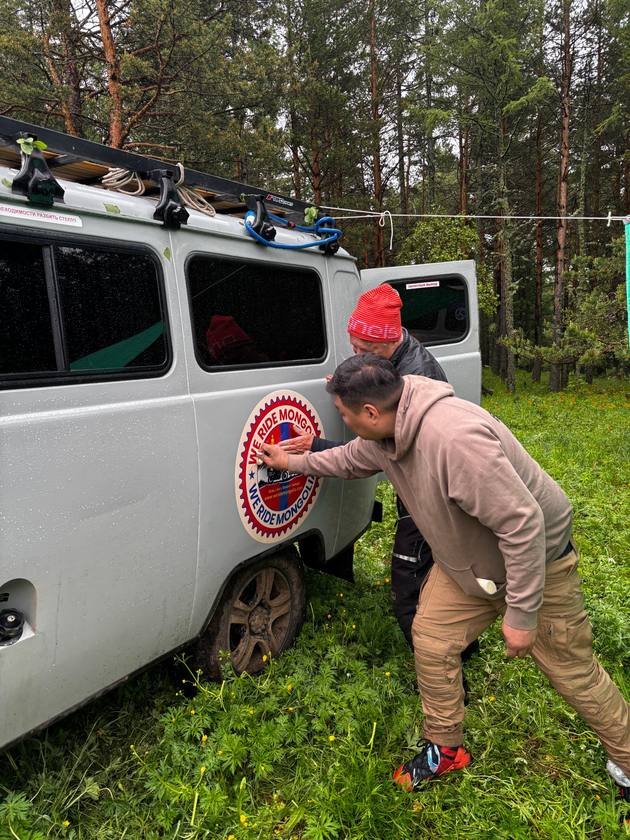 Fixing the We Ride Mongolia sticker on the support van