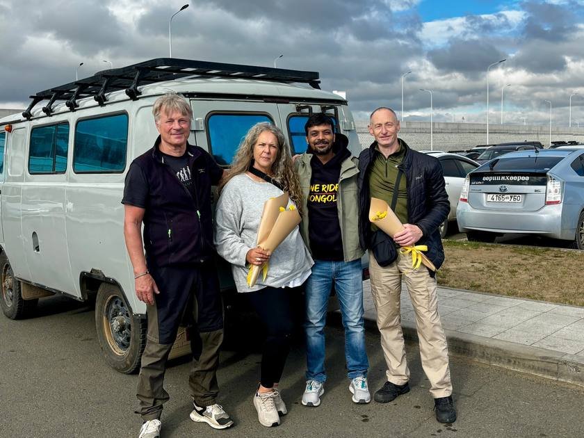 Riders and the We Ride Mongolia team with flowers at the van