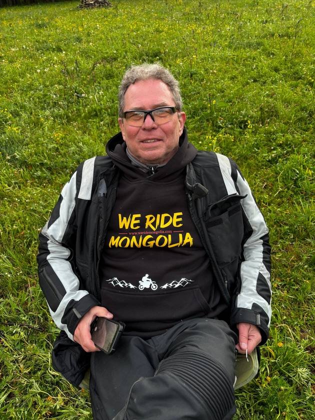 Rider in a We Ride Mongolia hoodie on the grass